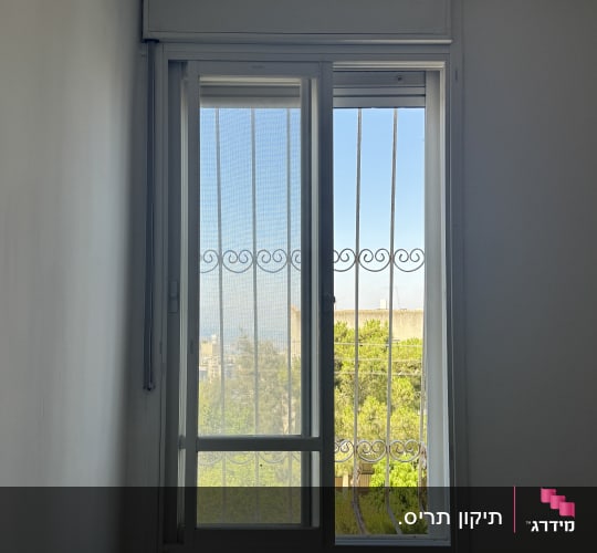 חלון עם תריסים ומסגרת מתכת